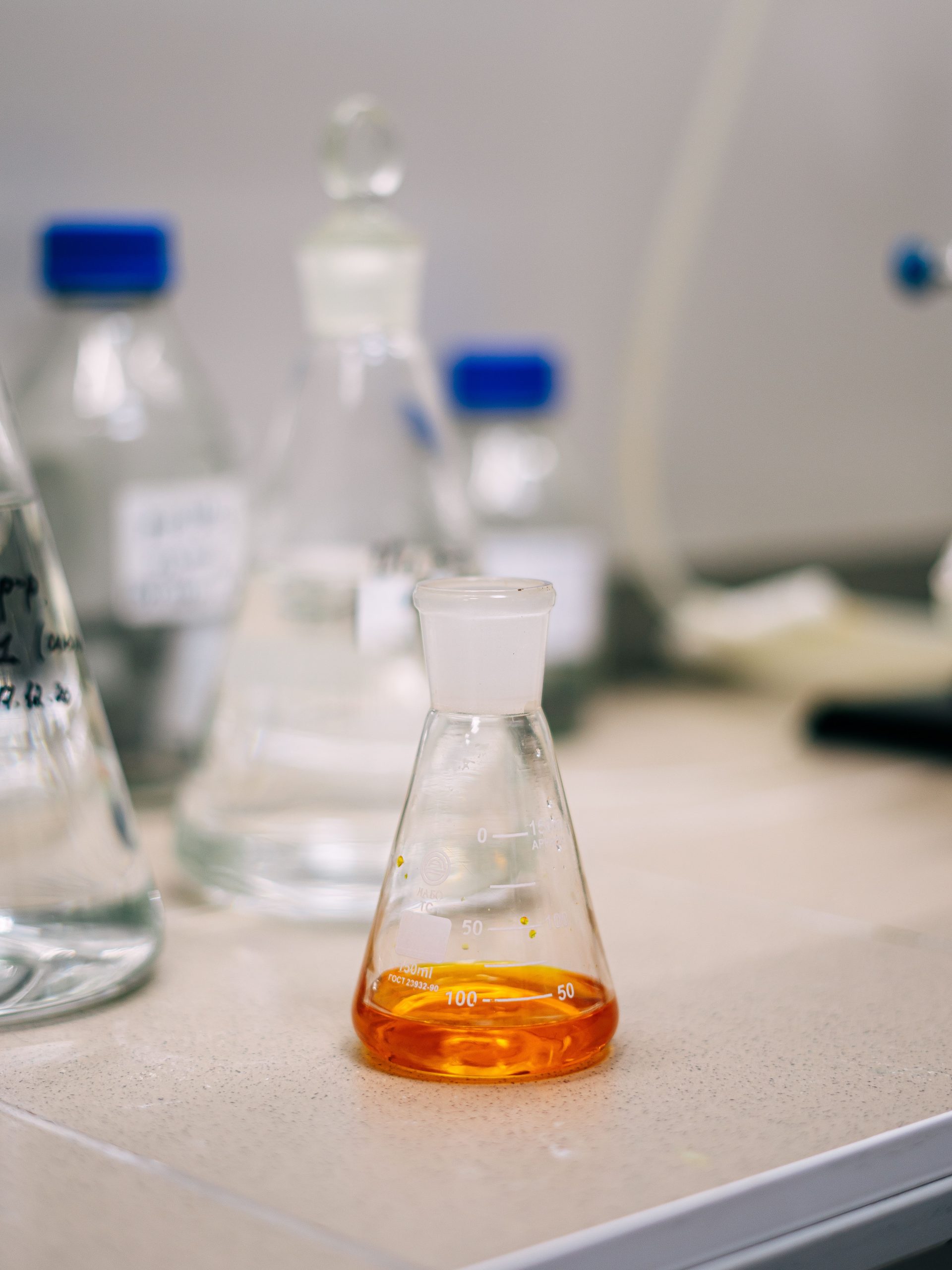 Sulfurized Fatty Acid Ester golden‑orange lubricant additive liquid in Erlenmeyer flask lab sample