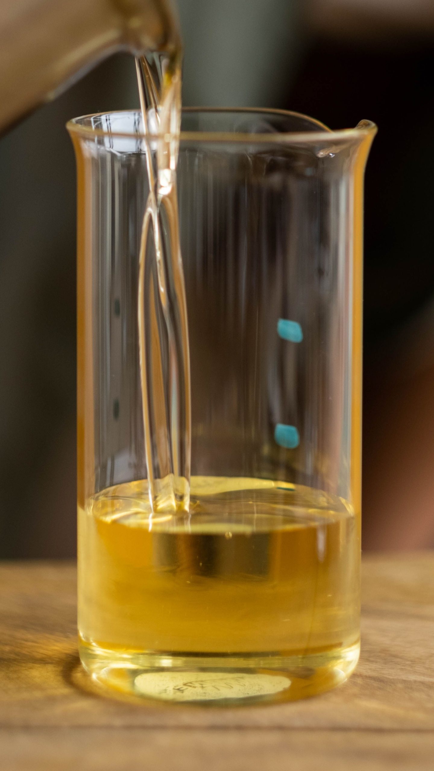 Pale yellow ZDDP liquid sample in beaker, lubricant anti-wear additive