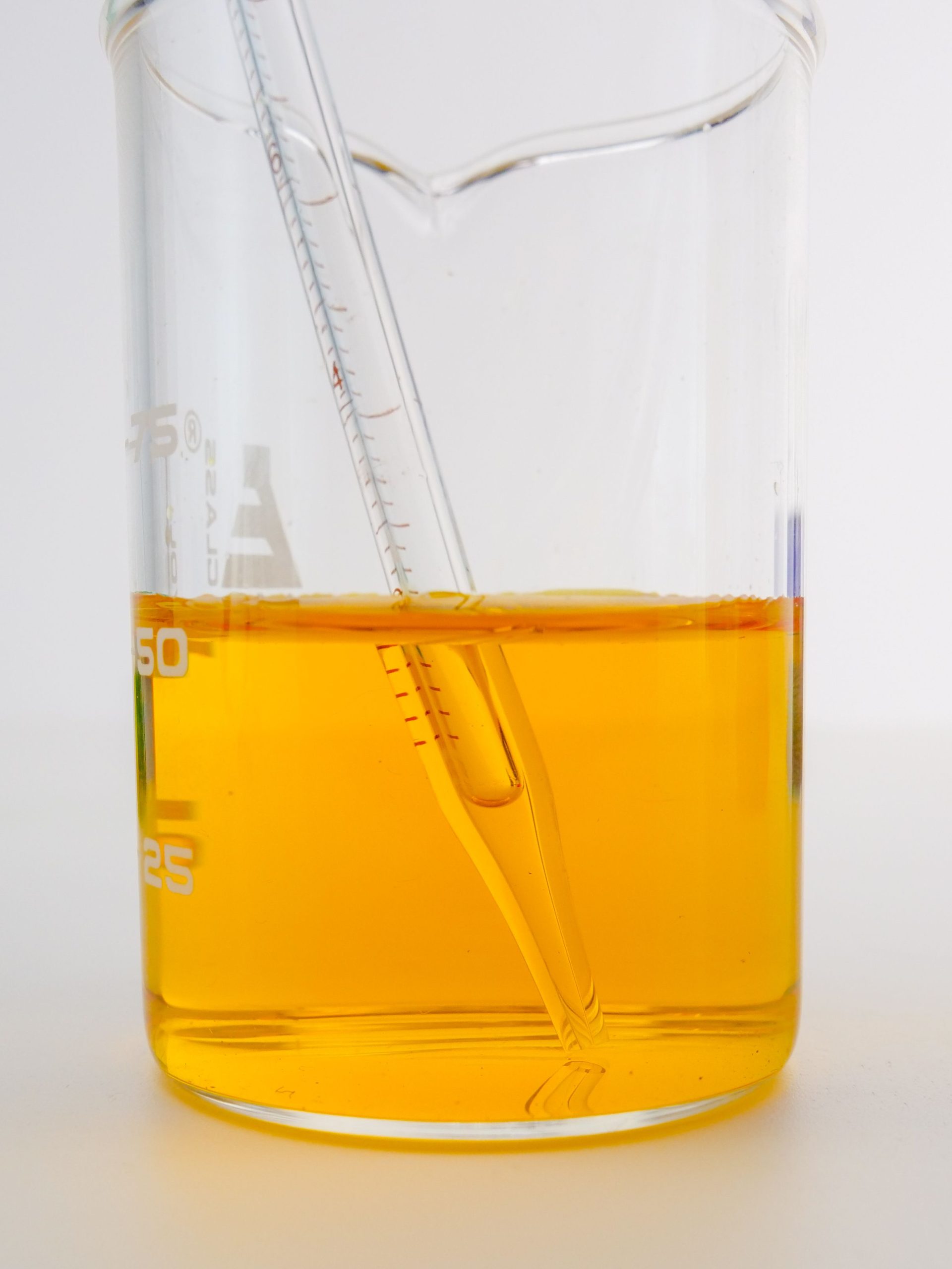 Orange‑amber sulfur‑phosphorus gear oil additive package liquid in beaker