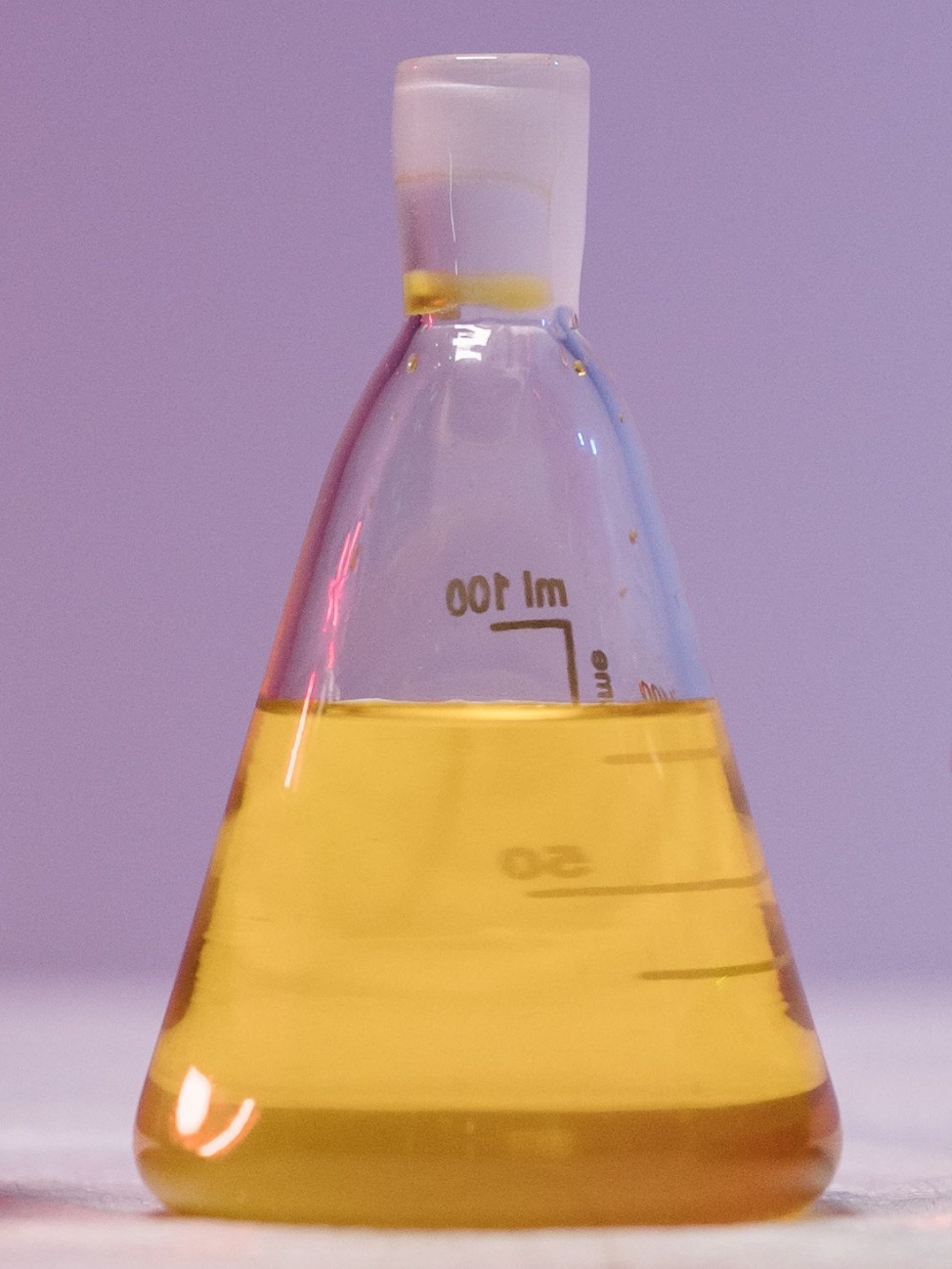 Golden yellow succinimide lubricant additive liquid in Erlenmeyer flask